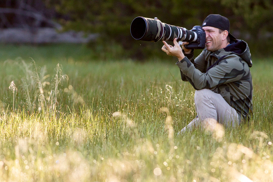 Nature Photographer John Fox on a shoot in tall grass with a telephoto lens.